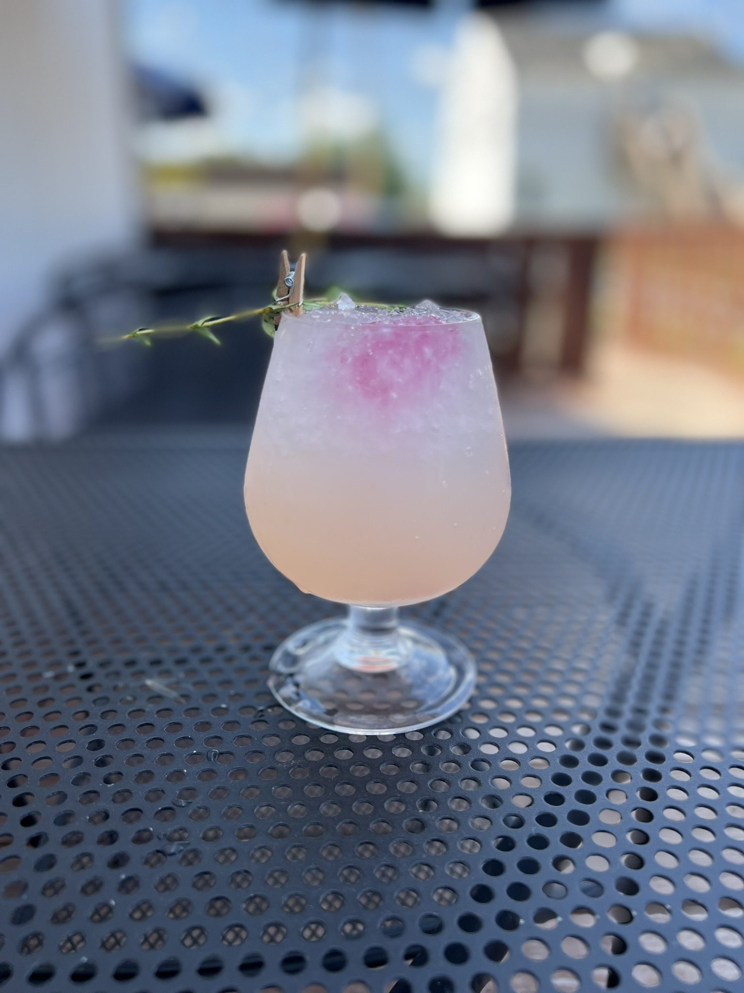 Signature cocktail with crushed ice and a sprig of thyme